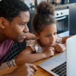 A father helping his daughter with homeschool.