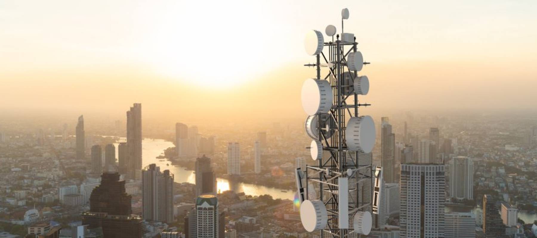 Telecommunication tower with 5G cellular network antenna against a city background