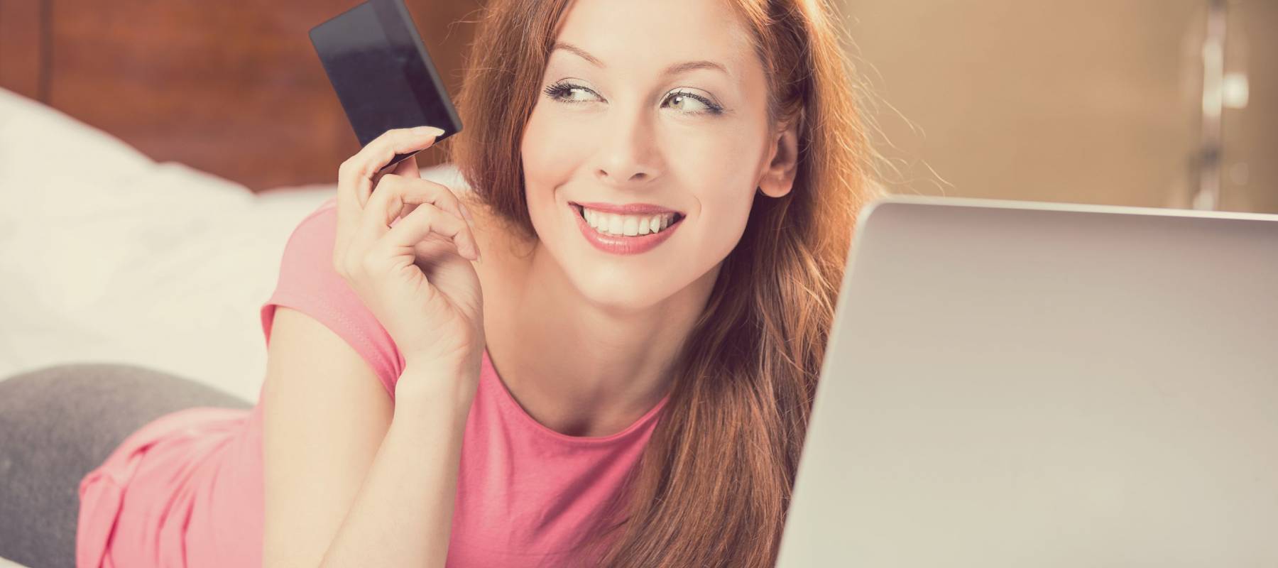 woman with laptop shopping on line holding showing credit card