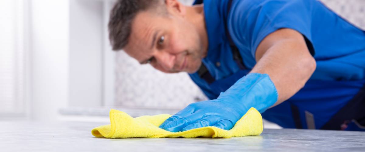 Man cleaning kitchen counter tops