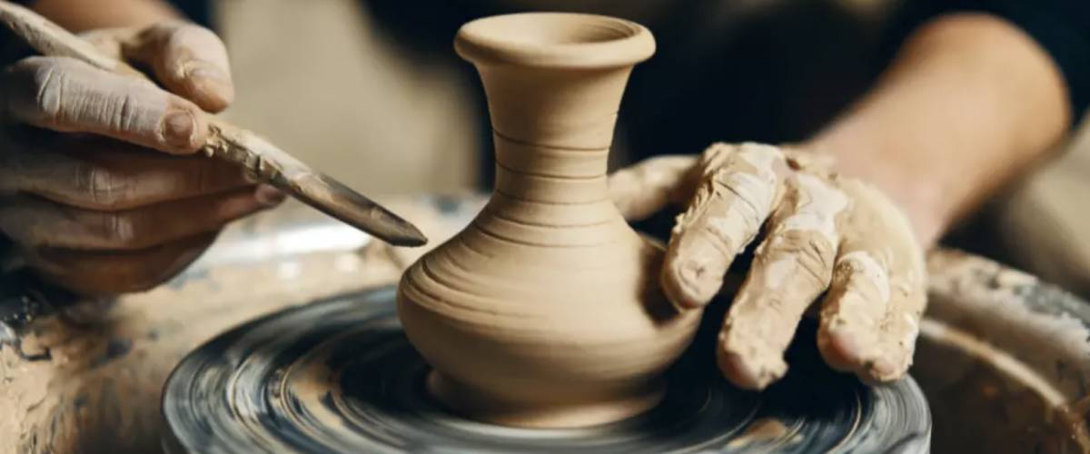 Hands making clay pottery