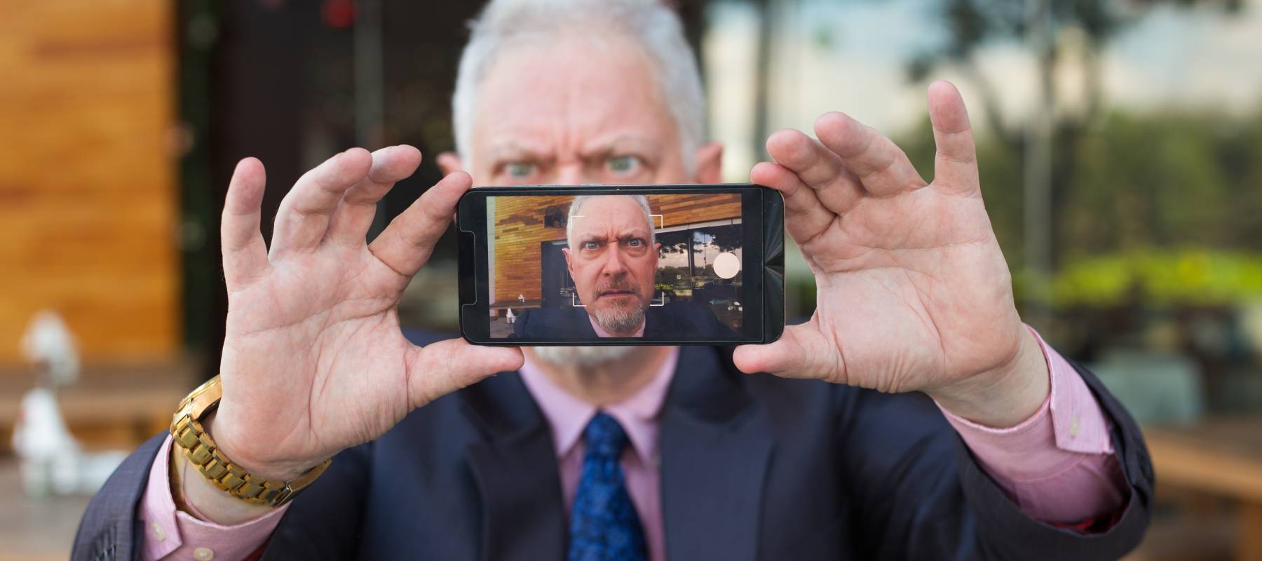 Business frowns as he takes a selfie
