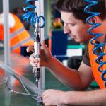 Men during precision work on production line, horizontal