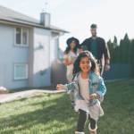 Parents and daughter playing in yard outside their house