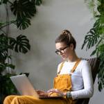 Focused millennial woman gardener watching educational webinar on laptop, remotely online work