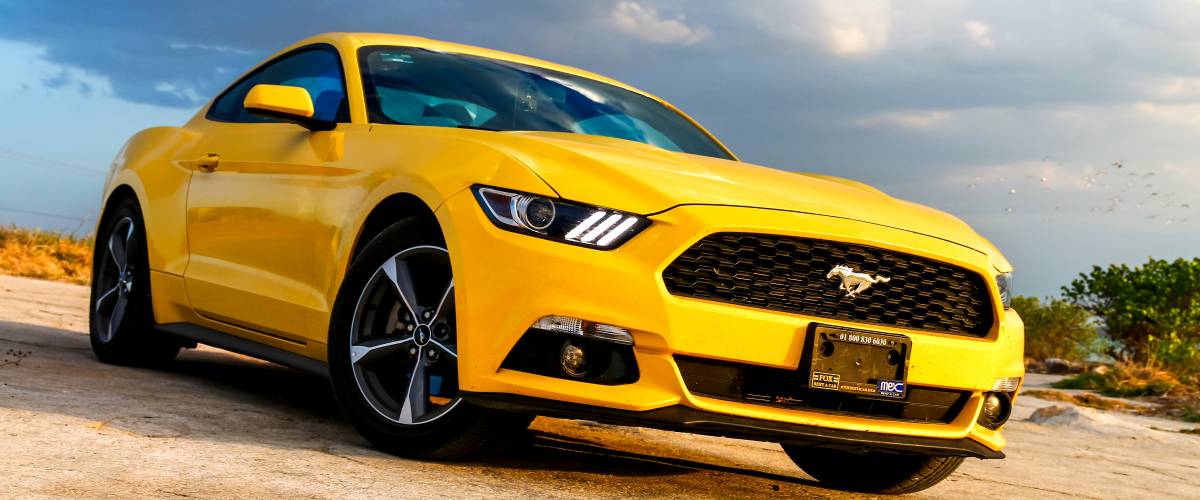 Yellow muscle car Ford Mustang at the countryside.