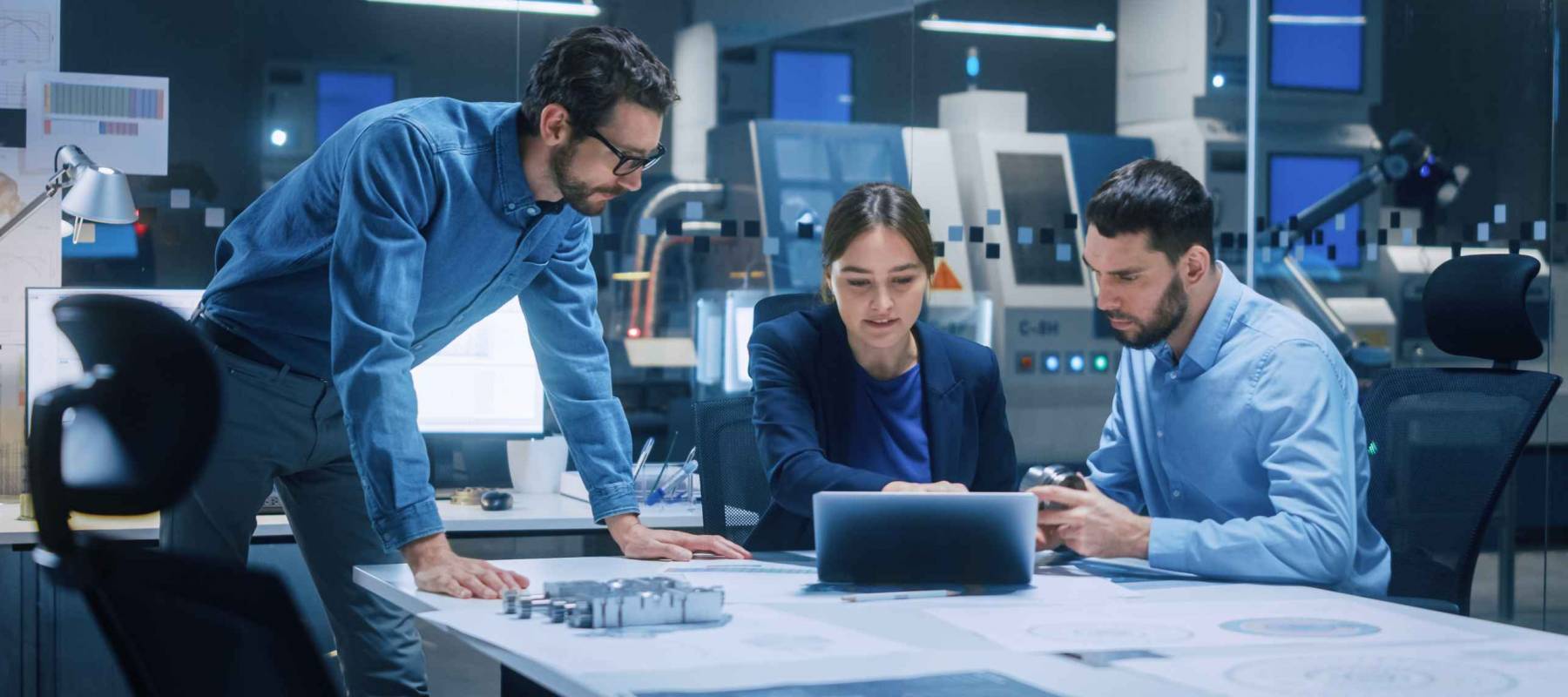 Factory Office Meeting Room: Team of Engineers Gather Around Conference Table, They Discuss Project Blueprints, Inspect Mechanism, Find Solutions, Use Laptop. Industrial Technology Factory