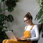 Focused millennial woman gardener watching educational webinar on laptop, remotely online work