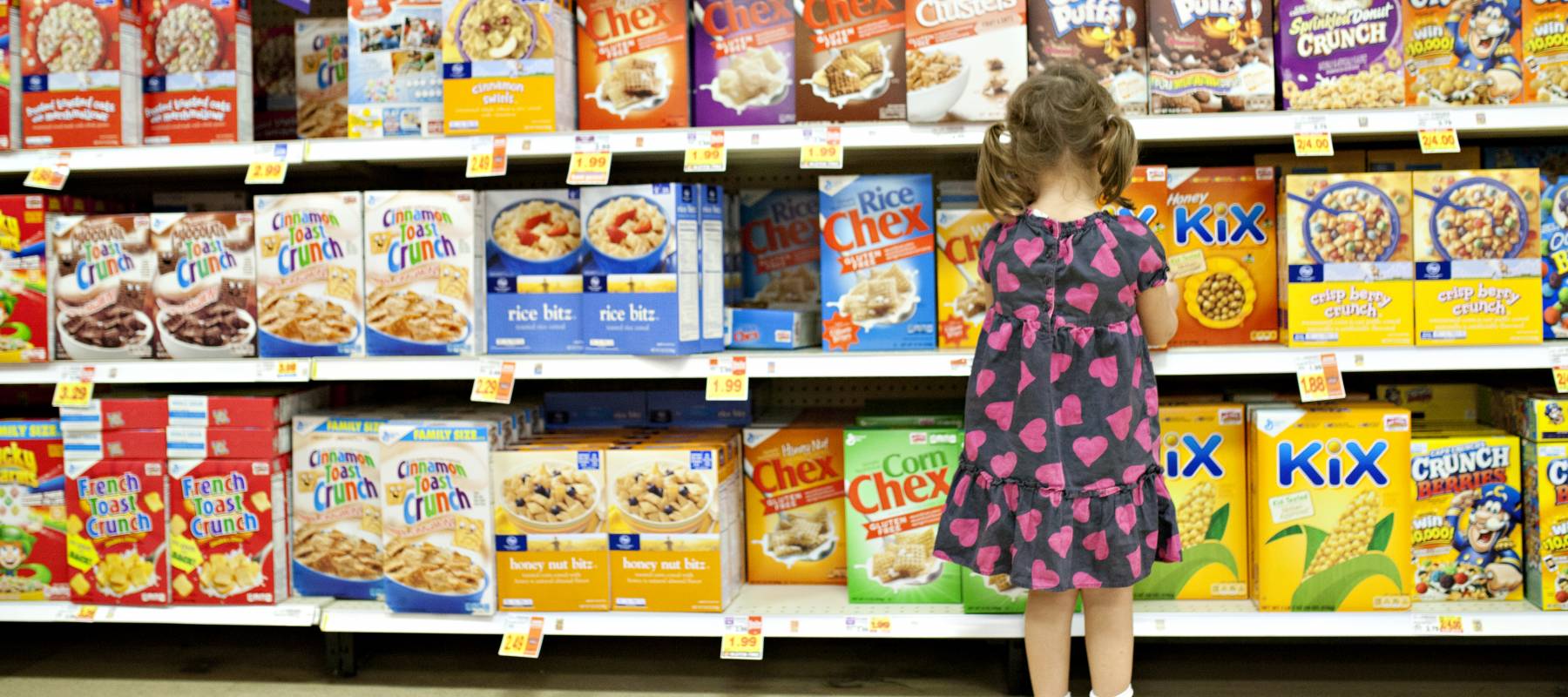 Little girl in grocery store cereal aisle