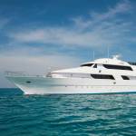 A luxury private motor yacht under way on tropical sea with bow wave
