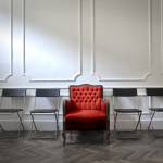 Red VIP chair in the centre of basic folding chairs, wealth concept