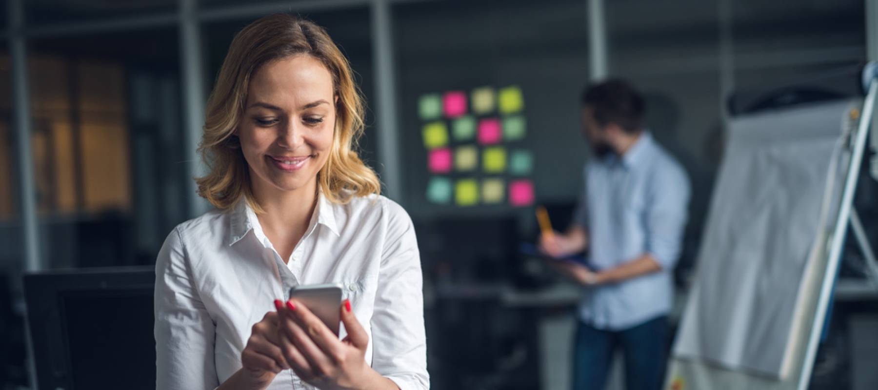 Business woman looks at phone