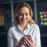 Business woman looks at phone