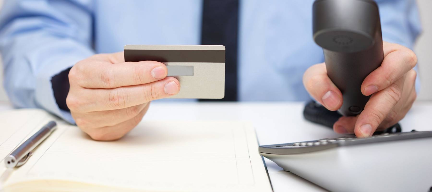 businessman with credit card dialing phone for  support