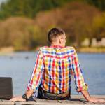 Man with laptop at lake