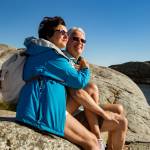 Mature couple sitting on the rocky coastline