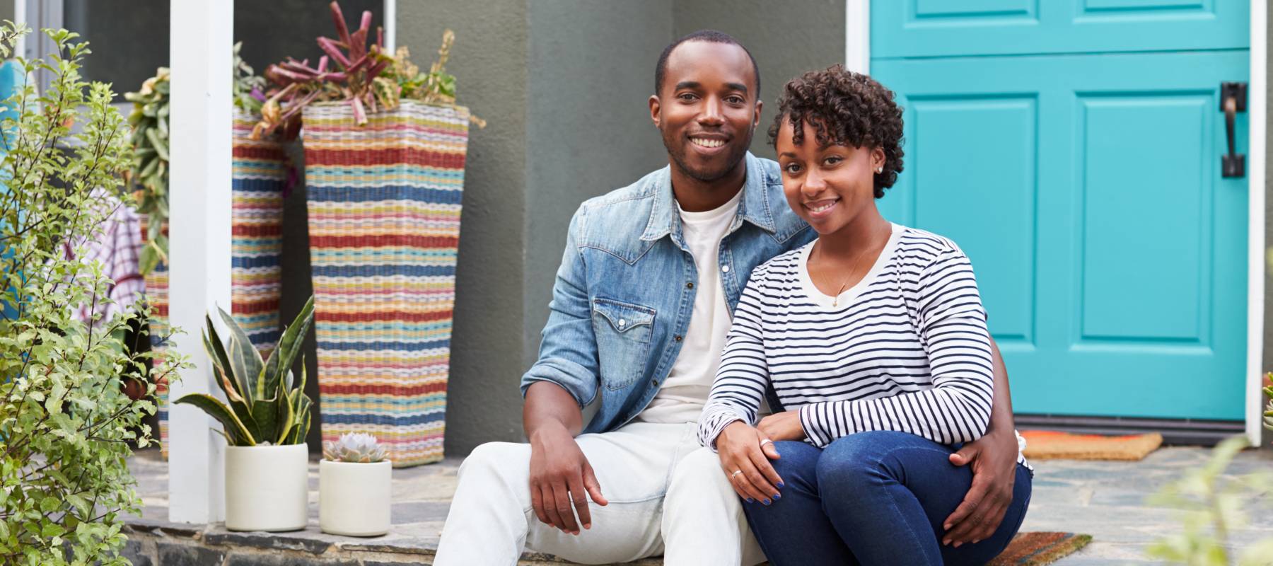 Happy couple on the steps of their home