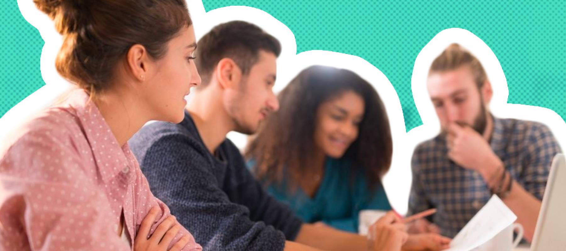 Group of students sit at a table looking at forms.