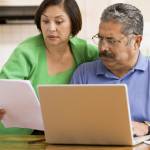 Older couple looks surprised while going through documents.