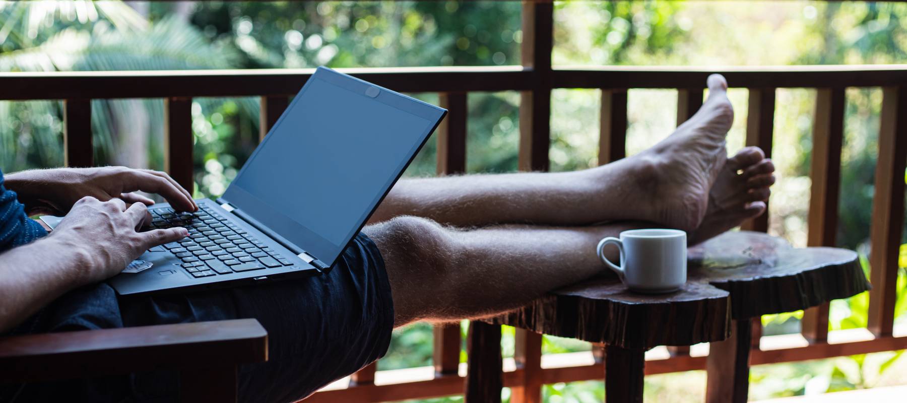 Man working at a computer in a tropical location