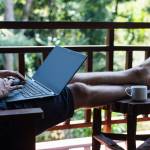 Man working at a computer in a tropical location