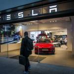 Man walking past a Tesla store