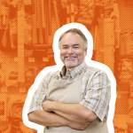 Portrait of a happy middle-aged salesperson with arms crossed in hardware store.