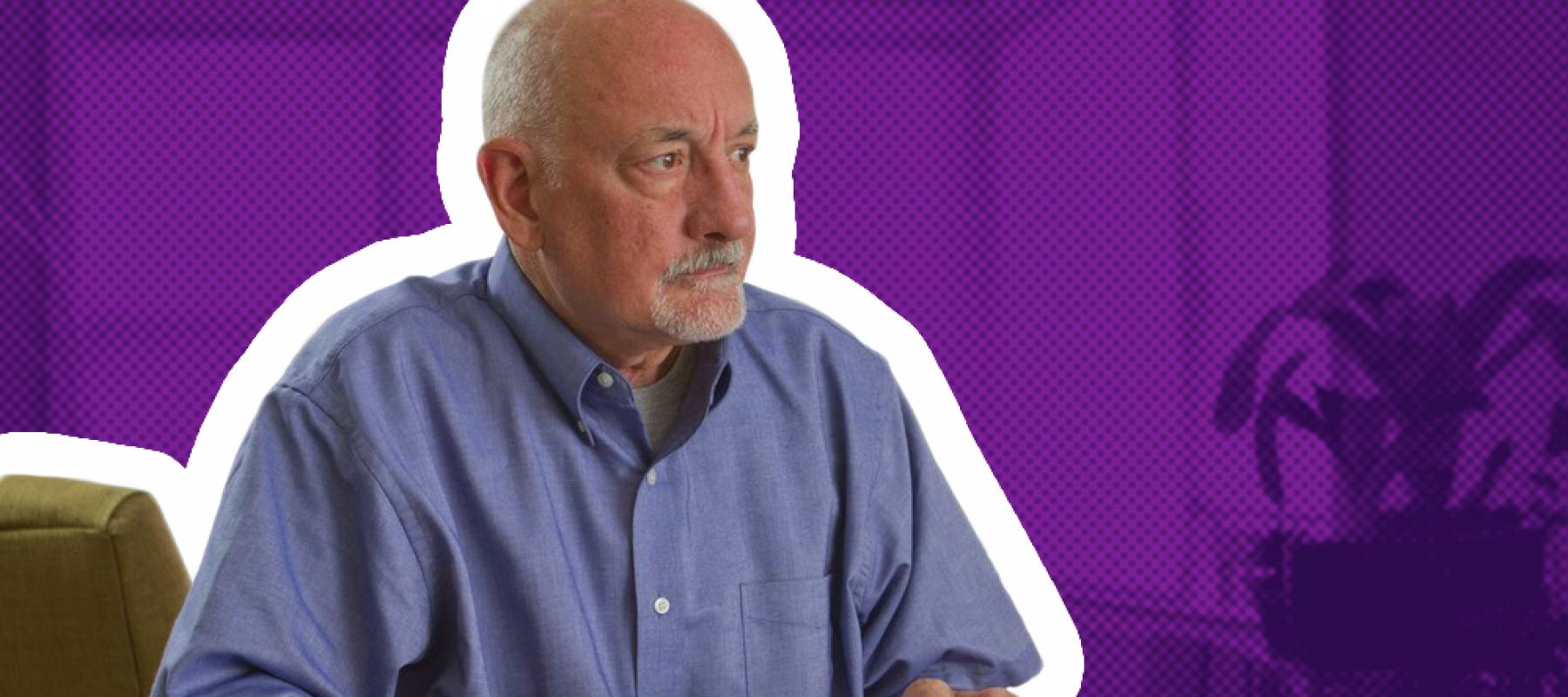 Man sits at table with bills, looking concerned and glancing off to the side of the camera.