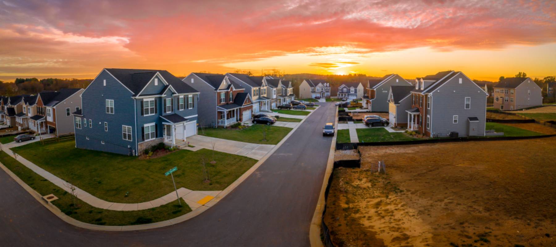 Aerial view of new construction cul-de-sac street with luxury houses with the sun setting.