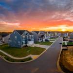 Aerial view of new construction cul-de-sac street with luxury houses with the sun setting.
