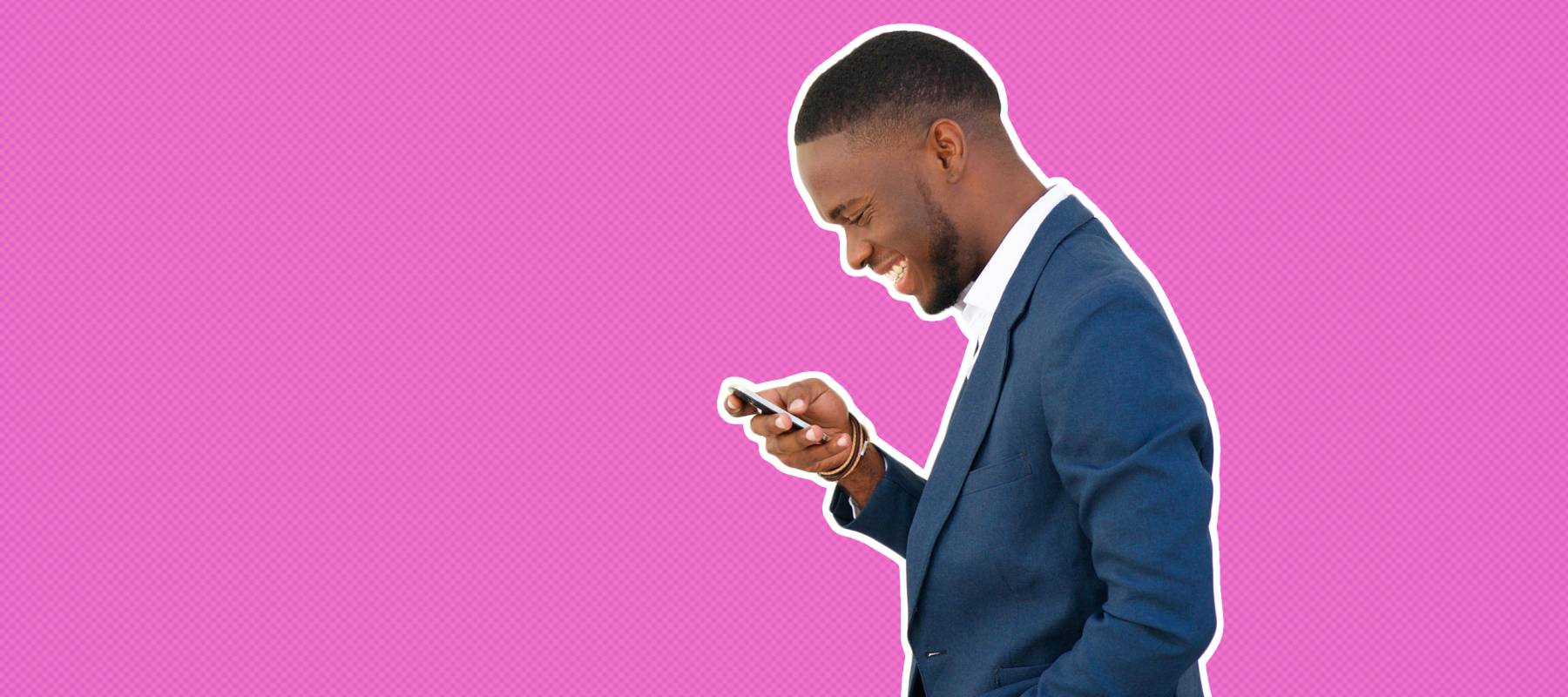 A man smiling and looking at his phone