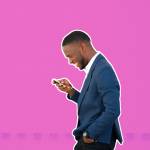 A man smiling and looking at his phone