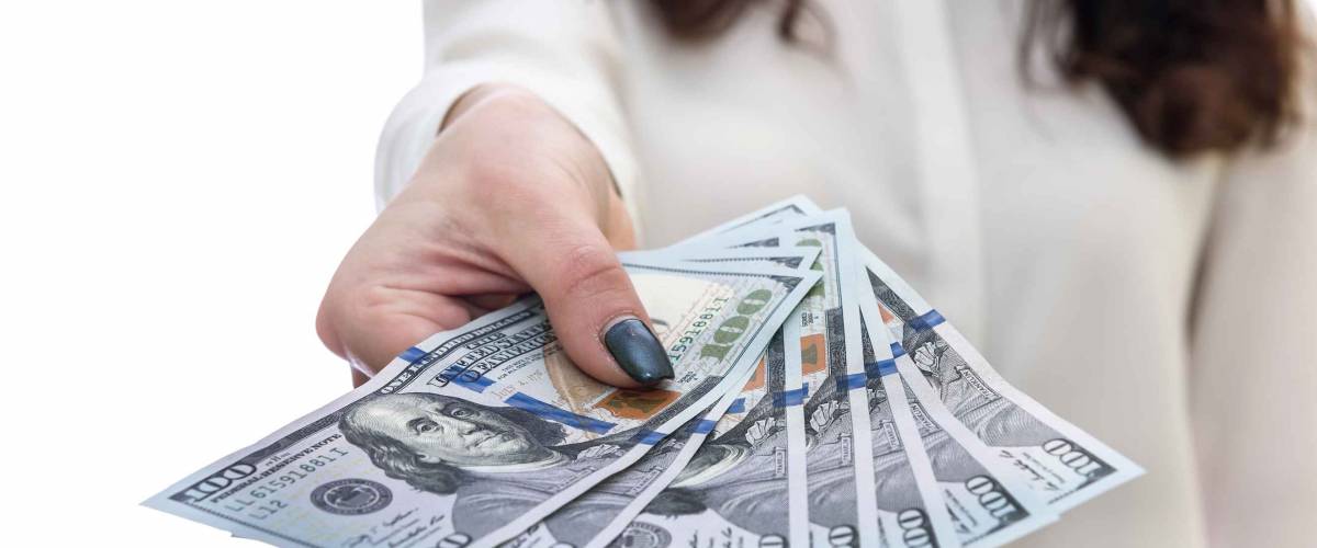 Female hand offering dollar banknotes in fan