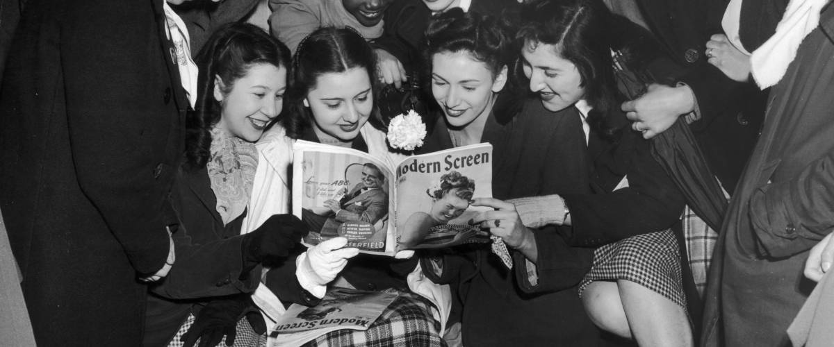 Teenage girls looking over a movie program