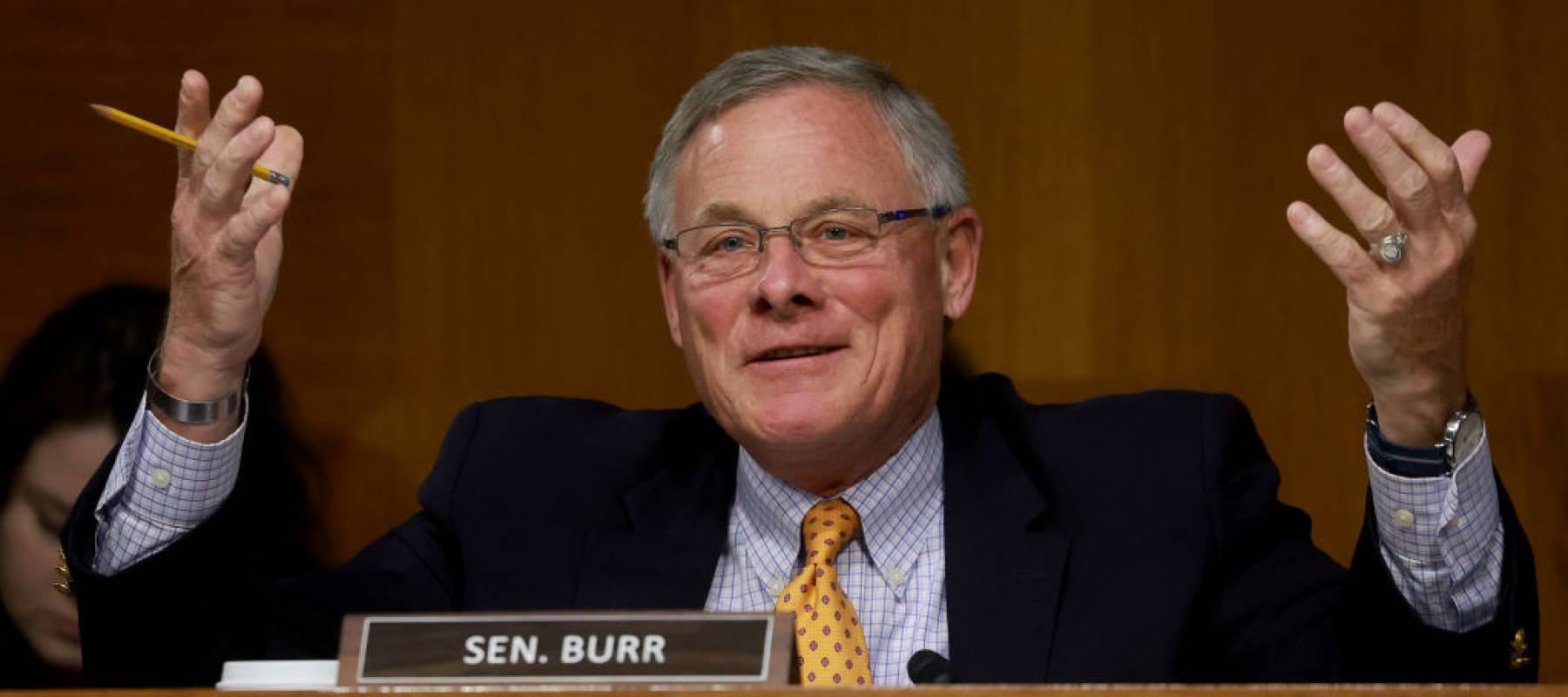 Senate Richard Burr speaks with his hands held up in a questioning gesture, in the middle of speaking.