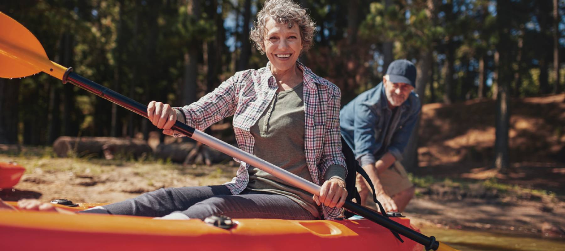 Older couple getting ready to head out on the water in a kayak.