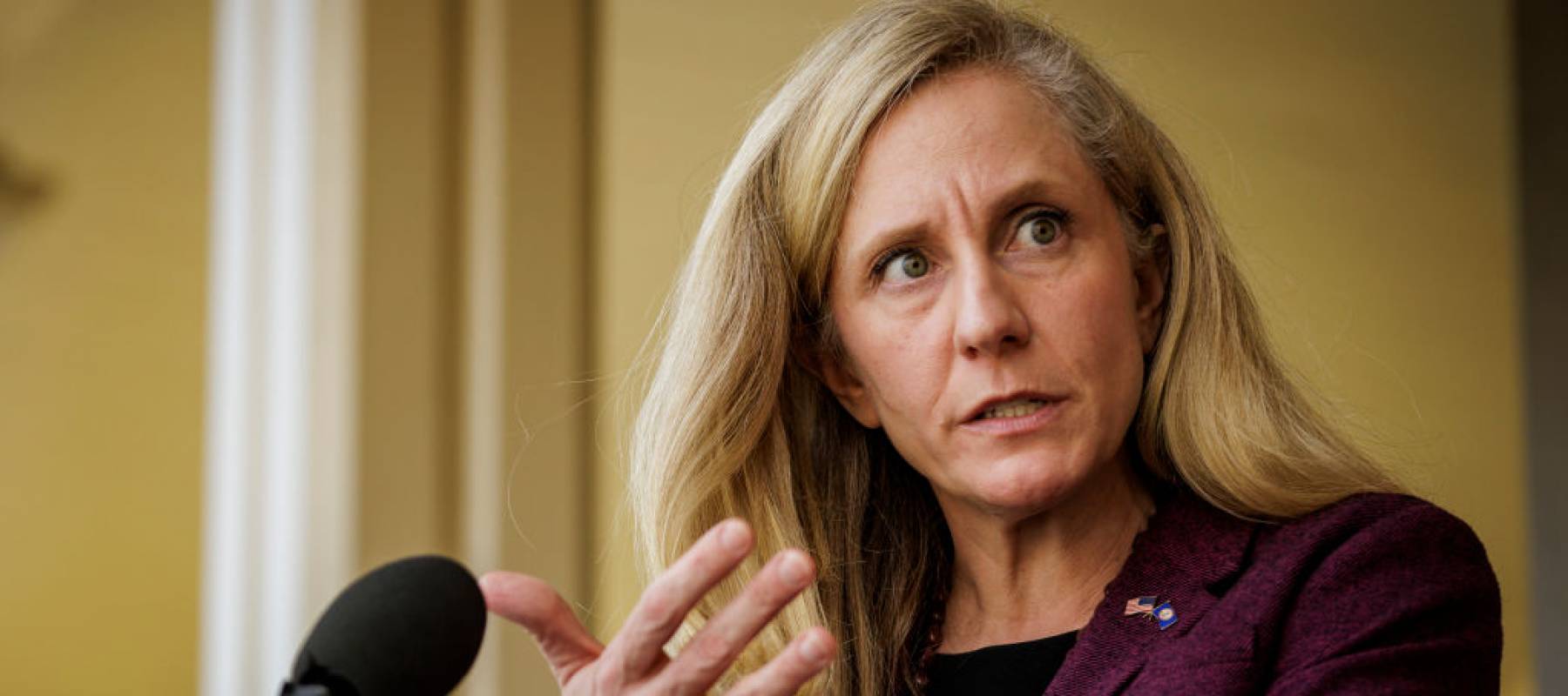 Rep. Abigail Spanberger stands in front of a podium, with