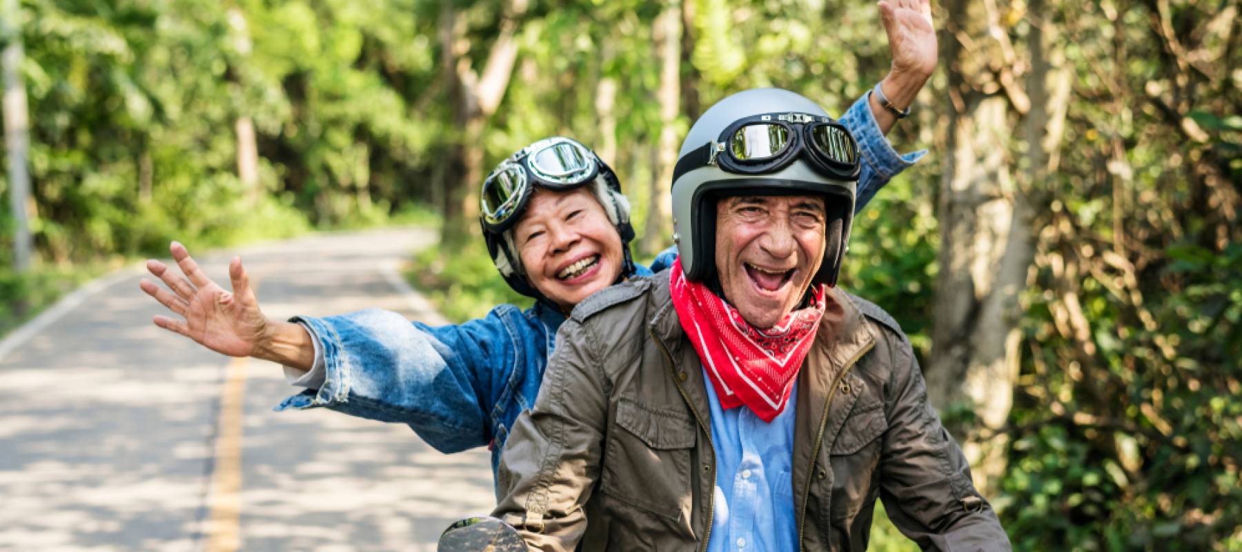 Happy senior couple riding a classic scooter.