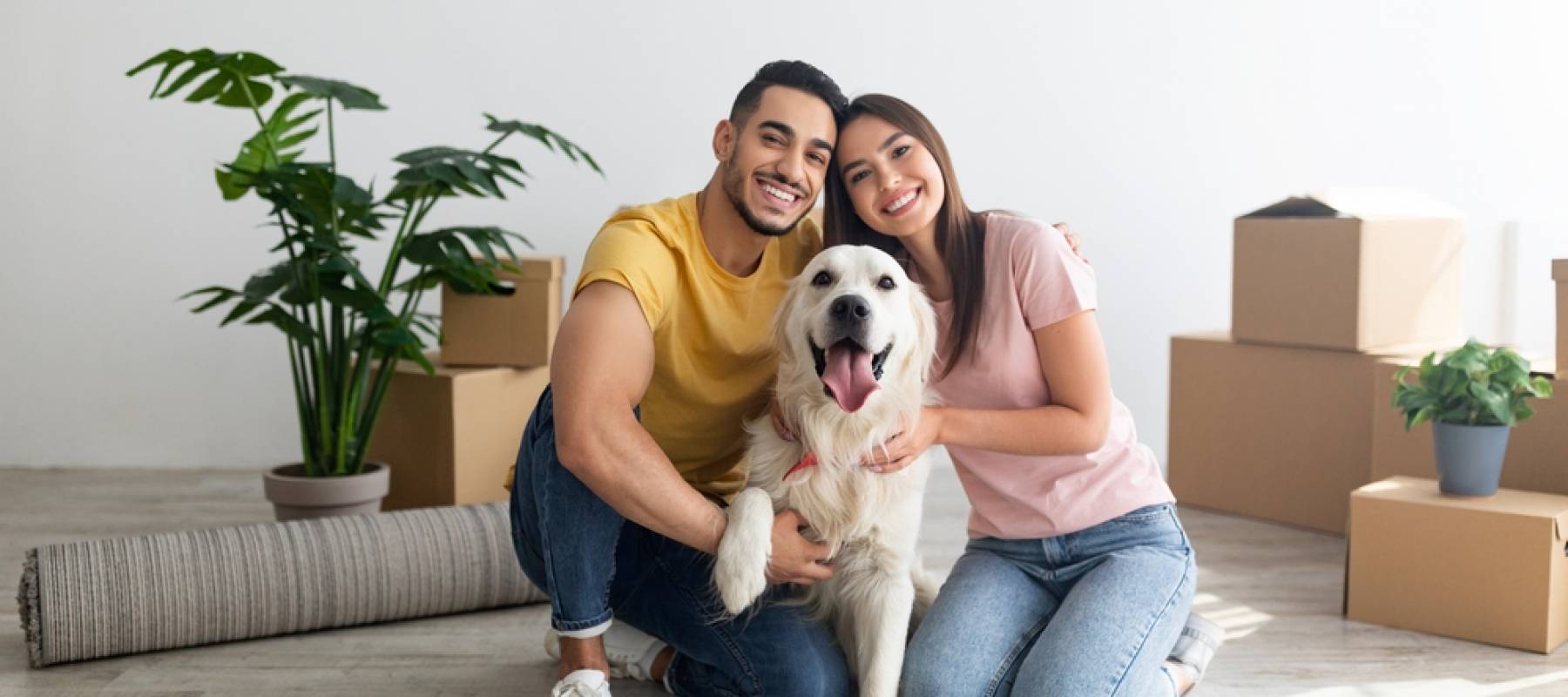 Millennial couple at home with a pet.
