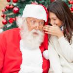 Shocked Santa Claus listening to girl's wish in front of Christmas tree