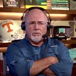 Dave Ramsey sits on set of his show with an incredulous look on his face and his arms crossed.