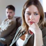 Portrait of offended young woman ignoring her angry partner