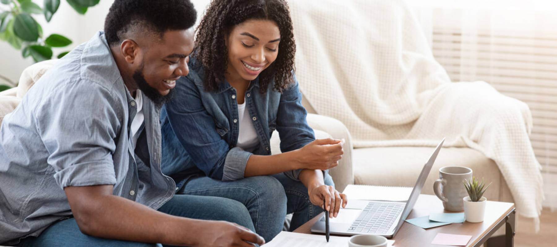 Young couple sitting on couch discussing finances