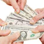 Many hands of senior people holding dollar money bills