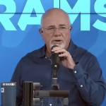 Dave Ramsey speaks into a microphone on set of his talk show.