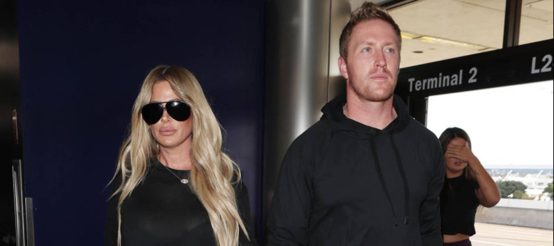 Kim Zolciak and Kroy Biermann walking into an airport, looking serious.
