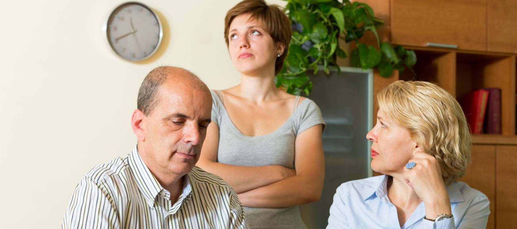 Adult daughter asking elderly parents for money at home, rolling her eyes behind them.