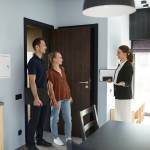 Side view portrait of female real estate agent meeting young couple