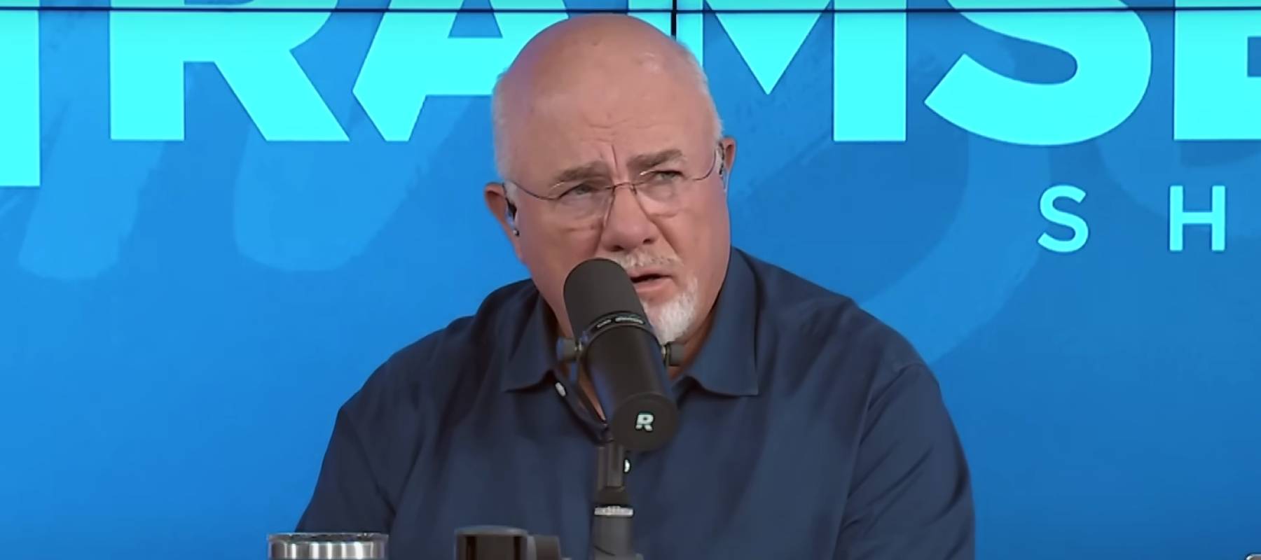Dave Ramsey seem on the set of his show, making an incredulous face.