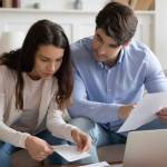 Close up young couple checking mortgage or loan agreement documents
